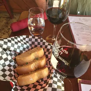 a basket of breadsticks and a glass of wine