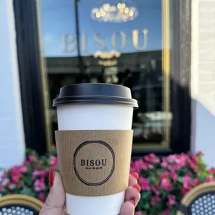 a hand holding a cup of coffee