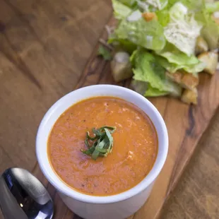 a bowl of tomato soup and a spoon