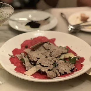 Generous amount of Black Truffle on Beef Carpaccio with Arugula and Shaved Parmesan