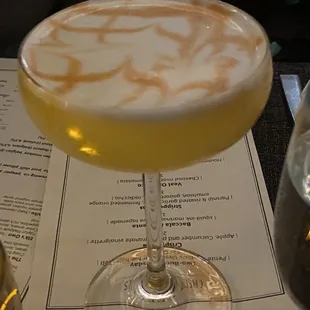 a drink in a coupe glass on a table