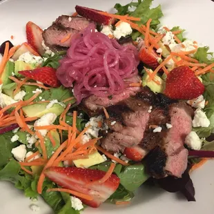 a plate of salad with meat and vegetables