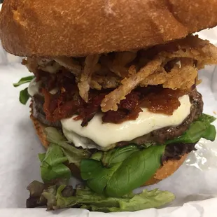 a burger with bacon, cheese, and lettuce