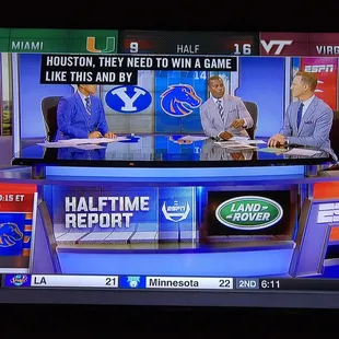 two men sitting at a table on a television show