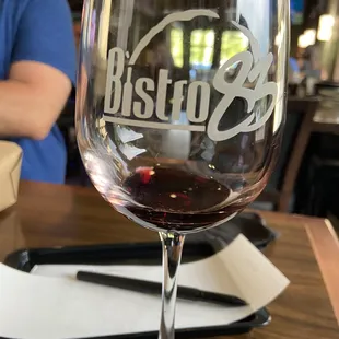 a glass of red wine on a table