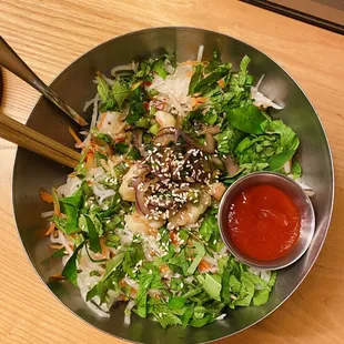 a bowl of asian food with chopsticks