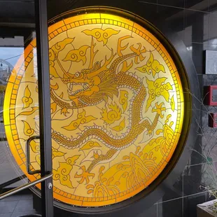 a yellow dragon on a round glass window