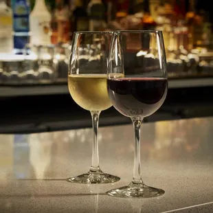 two glasses of wine on a bar