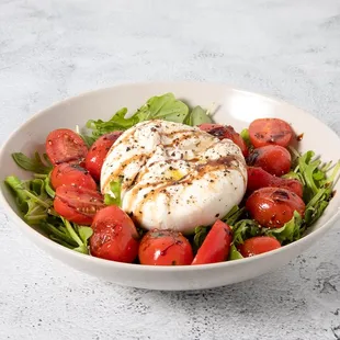 a bowl of salad with mozzarella and tomatoes