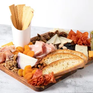a platter of cheese, bread, olives, and meats