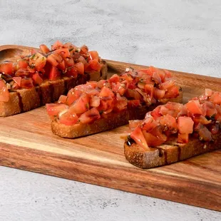 slices of bread with tomatoes on a cutting board
