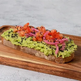 a piece of bread with avocado and tomatoes