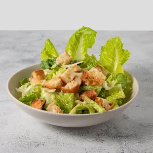a bowl of salad with croutons and lettuce