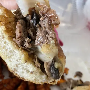 a hand holding a half eaten sandwich