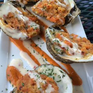 Southwestern Baked Oysters - Fresh oysters w/ cornbread sausage stuffing, Oaxaca cheese, white sauce and hot sauce
