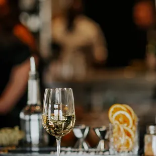 a glass of white wine on a bar