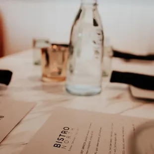 a menu and a bottle of water on a table