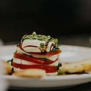 a stack of tomatoes and cheese on a plate