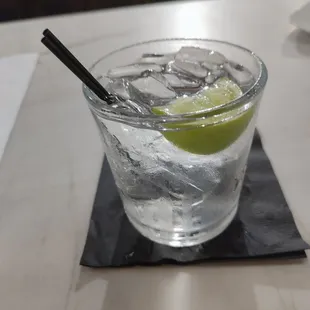 a glass of water with ice and lime