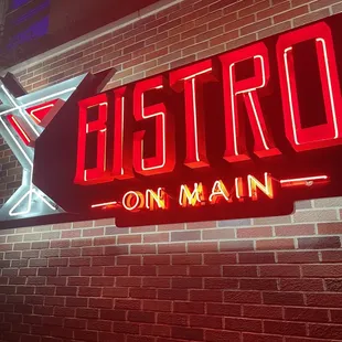a neon sign on a brick wall