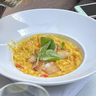a bowl of risotto with a garnish of basil
