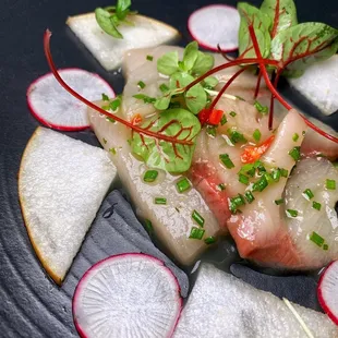 a plate of raw fish and radishes