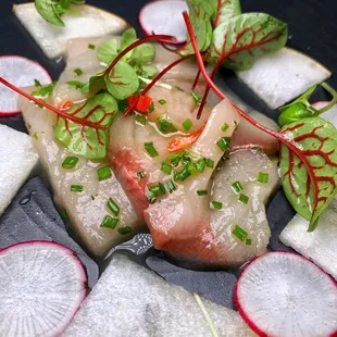 a plate of raw fish and radishes