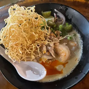 a bowl of noodles and a spoon