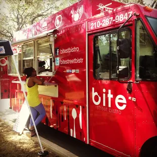 a woman leaning against a food truck