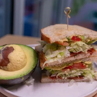 a sandwich and avocado on a plate
