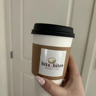 a hand holding a coffee cup