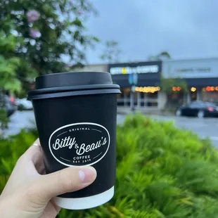 a hand holding a coffee cup
