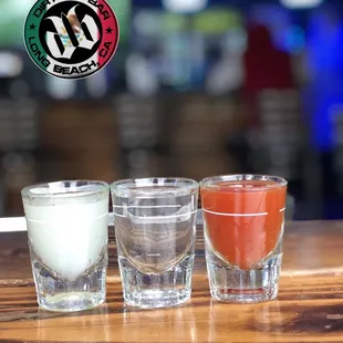 three shot glasses on a bar