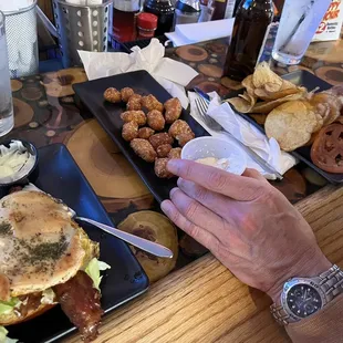 a person eating a burger and pretzels