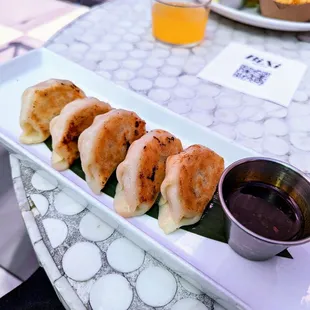 a plate of dumplings with dipping sauce