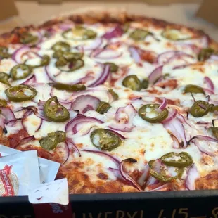 a pizza with onions and jalapenos