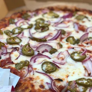 a pizza with onions and jalapenos