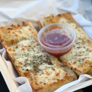 a tray of cheese bread with ketchup