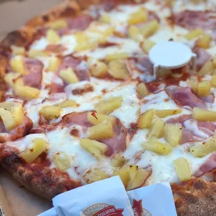 a pizza with pineapples and ham