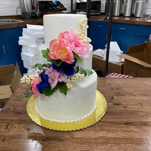a three tiered cake with fresh flowers