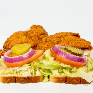 a sandwich with lettuce, tomato, pickles and pickles