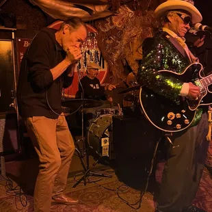 two men playing guitar and singing