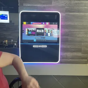 a woman sitting in a chair in front of a television