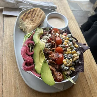 a bowl of salad with a side of bread