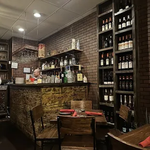 a bar with wine bottles on shelves