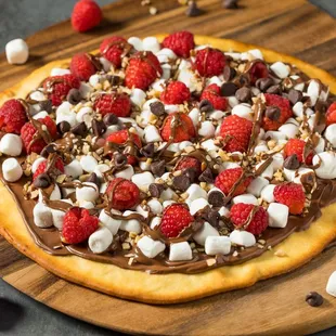 a chocolate pizza topped with raspberries and marshmallows