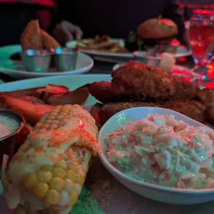 a plate of food including corn, coleslaw, and coleslaw