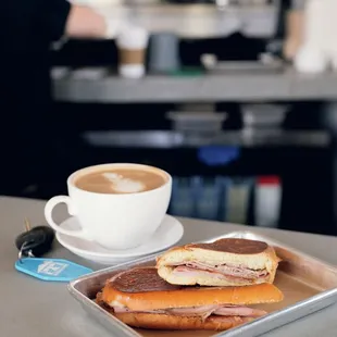 a tray with two sandwiches and a cup of coffee