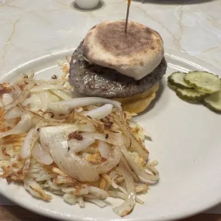Breakfast sandwich and hash browns with onions.