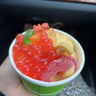 a person holding a bowl of gummy bears